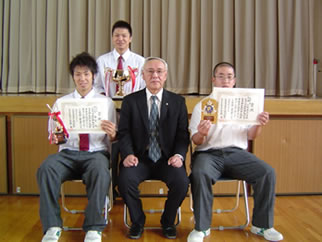 校長先生を囲んで,喜びの表情の部員代表